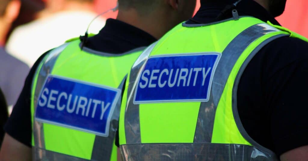 Two security guards in Bedfordshire wearing high visibility vests and ear pieces